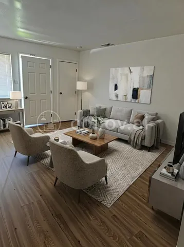 a living room with furniture and wooden floor