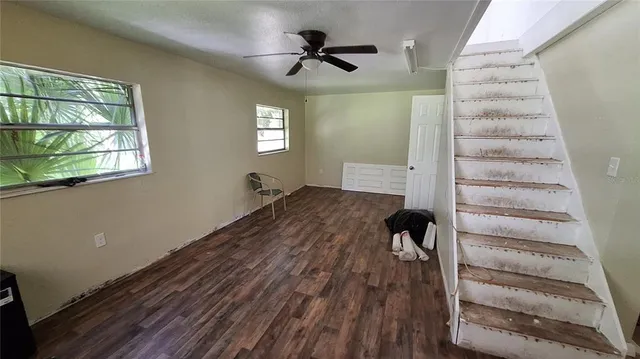a view of a livingroom with wooden floor and a ceiling fan
