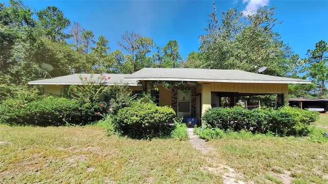 a view of a house with a yard and potted plants