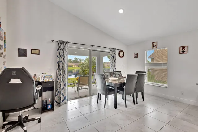 a dining room with furniture and a floor to ceiling window