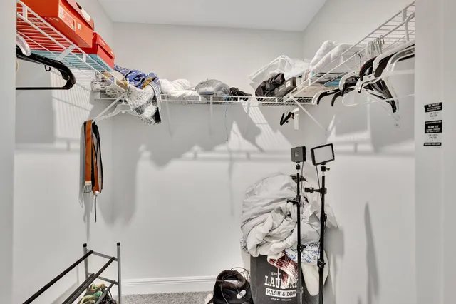 a view of walk in closet with clothes and shoes