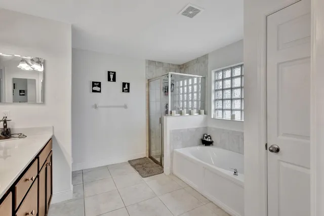 a spacious bathroom with a tub sink and mirror