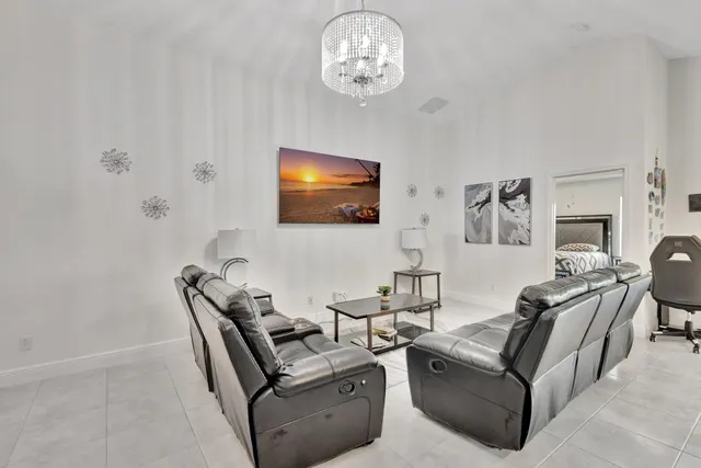 a living room with furniture a dining table and a chandelier