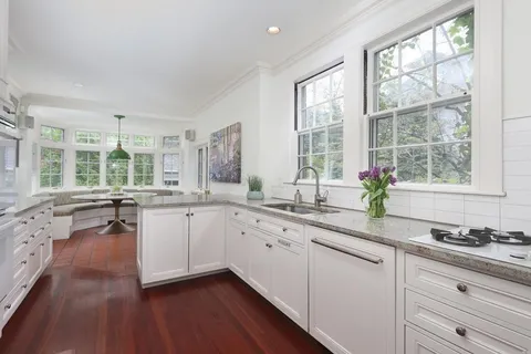 a kitchen with granite countertop white cabinets and a large window