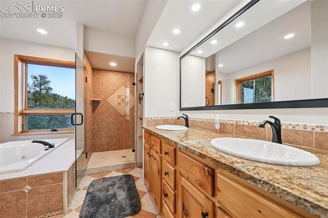 1417 Forest Road Manitou Springs, CO 80829 - Photo 24 of 50 5 piece en suite primary bathroom with jetted tub, dual sinks, stand in shower and spacious walk in closet