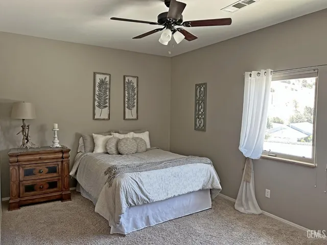 a bedroom with a bed a dresser and a window