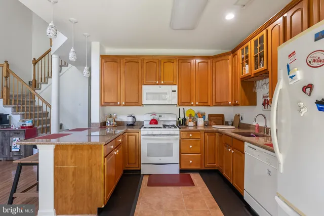 a kitchen with kitchen island a sink a stove top oven a counter space and cabinets