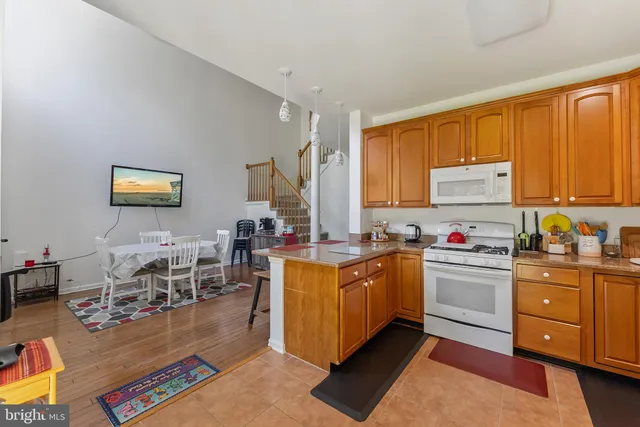 a kitchen with stainless steel appliances granite countertop a stove top oven a sink dishwasher and cabinets with wooden floor