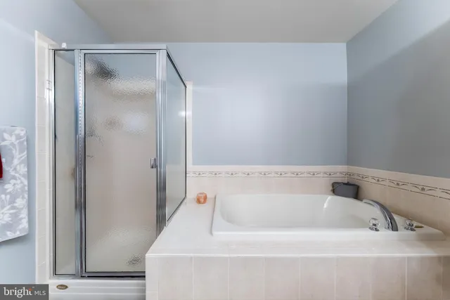 a bathroom with a tub sink and mirror