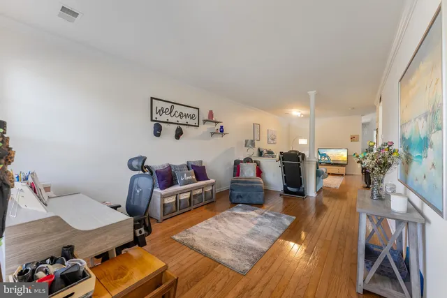 a living room with furniture and a wooden floor
