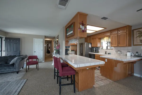 a bathroom with a granite countertop sink a toilet a shower and a mirror
