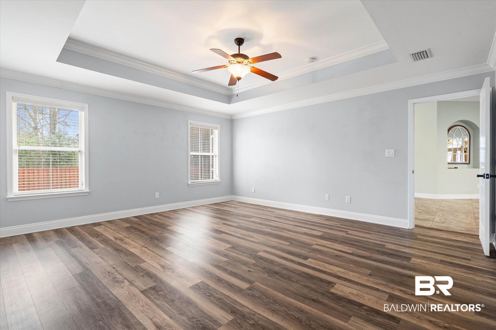 704 Edinburgh Avenue Foley, AL 36535 - Photo 19 of 32 Primary with ceiling fan, a raised ceiling, dark wood-type flooring, and ornamental molding
