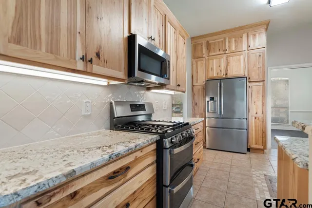 a kitchen with stainless steel appliances granite countertop a refrigerator stove and microwave