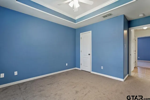 an empty room with a ceiling fan and a window
