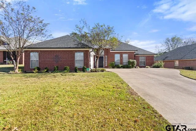 a front view of house with yard and trees around