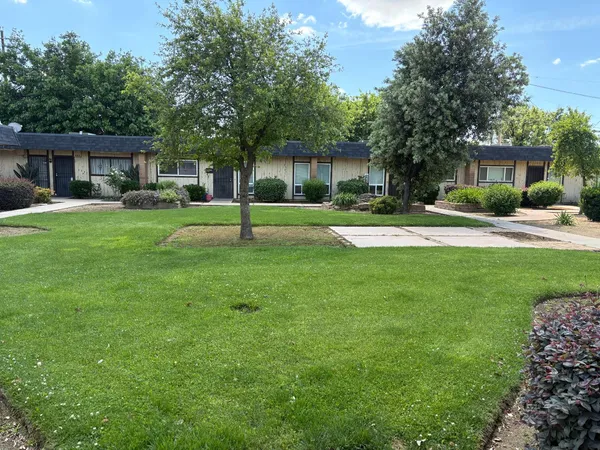 a view of a house with a yard and tree s