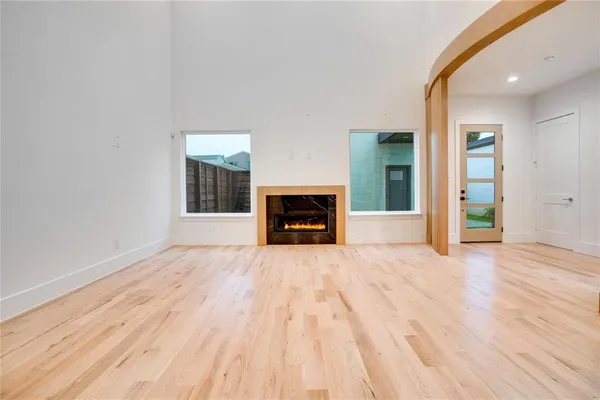 a view of empty room with wooden floor and fireplace