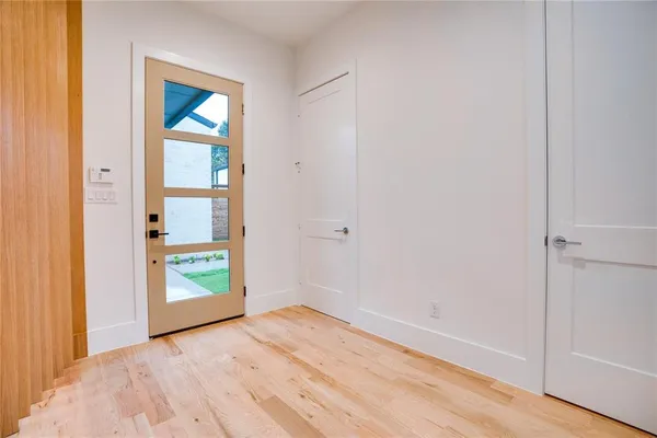 a view of an empty room with window and wooden floor