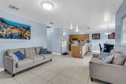 a living room with furniture and kitchen view