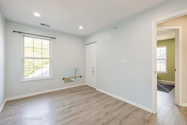 an empty room with wooden floor and a window