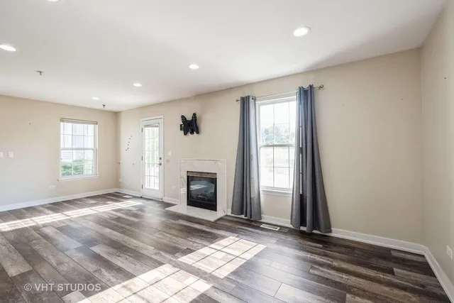 a view of an empty room with window and fire place