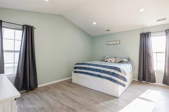 a bedroom with a bed and a large window