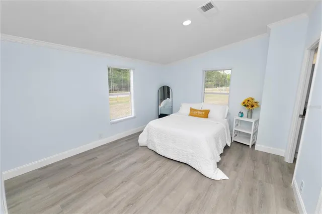 a bedroom with a bed and wooden floor