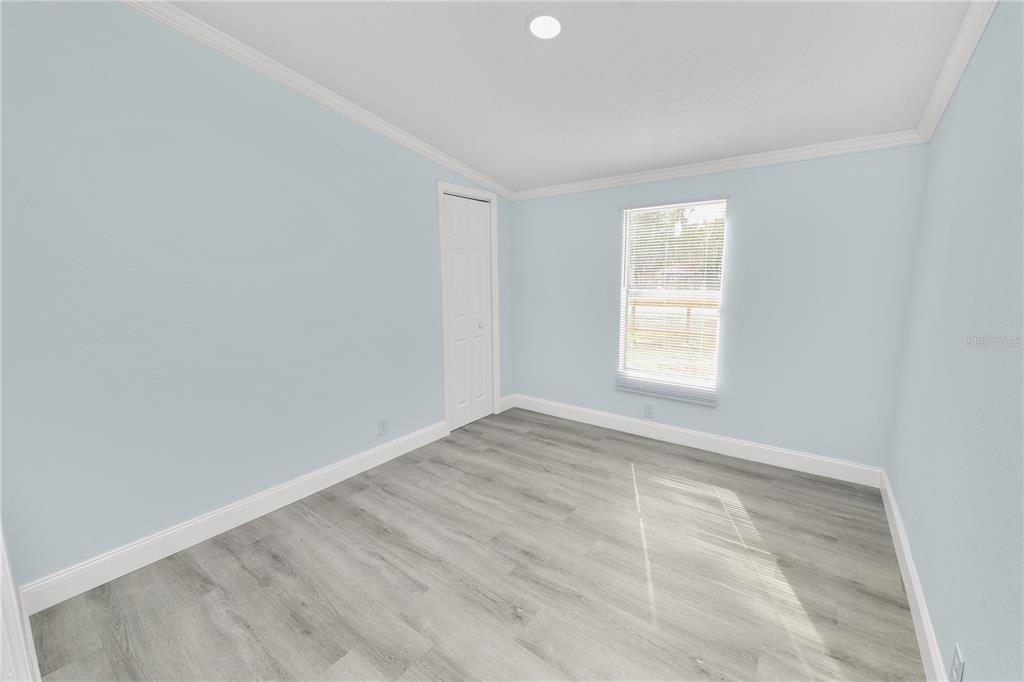 18805 St Paul Drive Spring Hill, FL 34610 - Photo 13 of 20 wooden floor in an empty room with a window