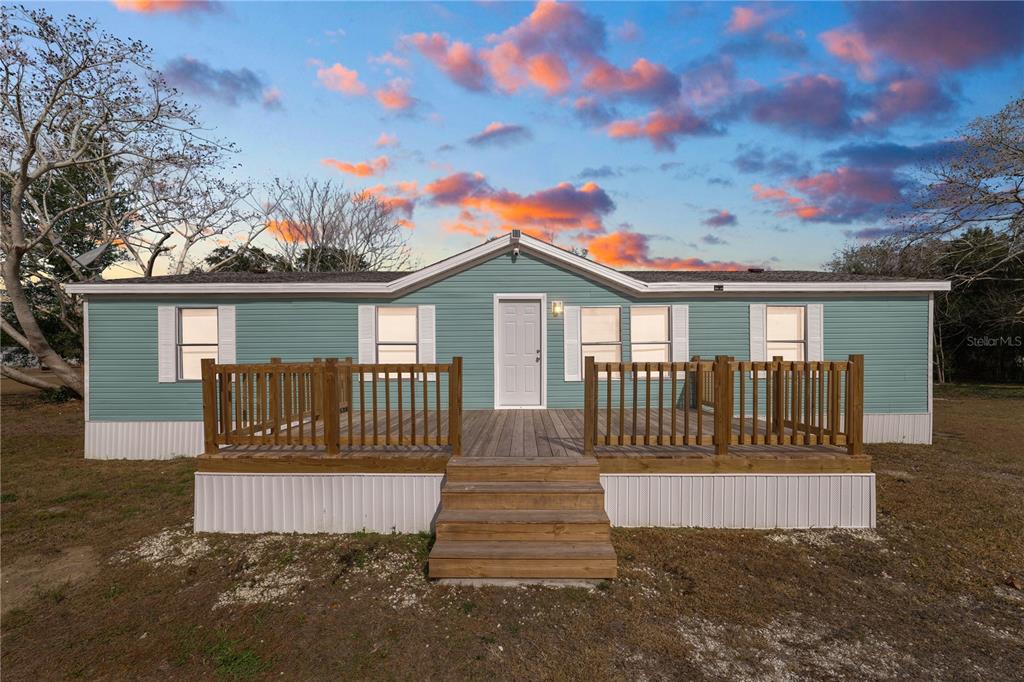 18805 St Paul Drive Spring Hill, FL 34610 - Photo 2 of 20 a view of a house with a small yard plants and large tree