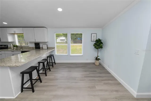 an open kitchen with granite countertop a stove and a sink