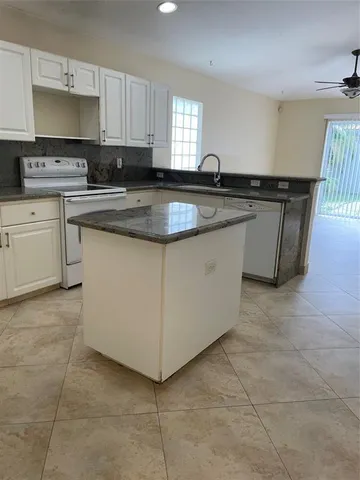 a kitchen with stainless steel appliances granite countertop a sink a stove a microwave a counter top and cabinets
