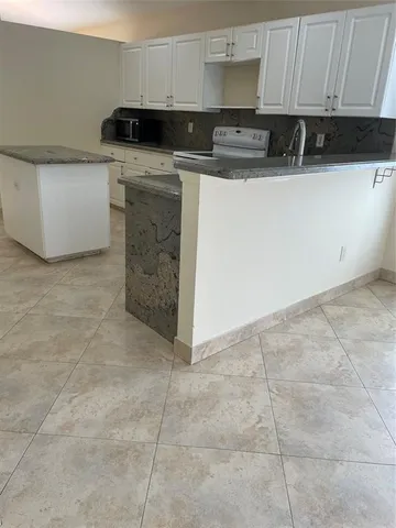 a kitchen with a sink a stove and cabinets