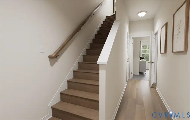 a view of staircase with lots of frames on wall and windows