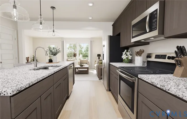 a kitchen with stainless steel appliances granite countertop a stove a sink and a microwave