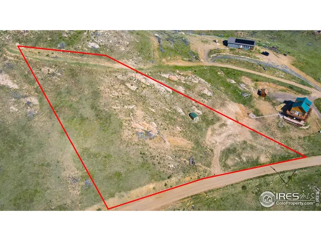 a view of a dry yard with mountains in the background