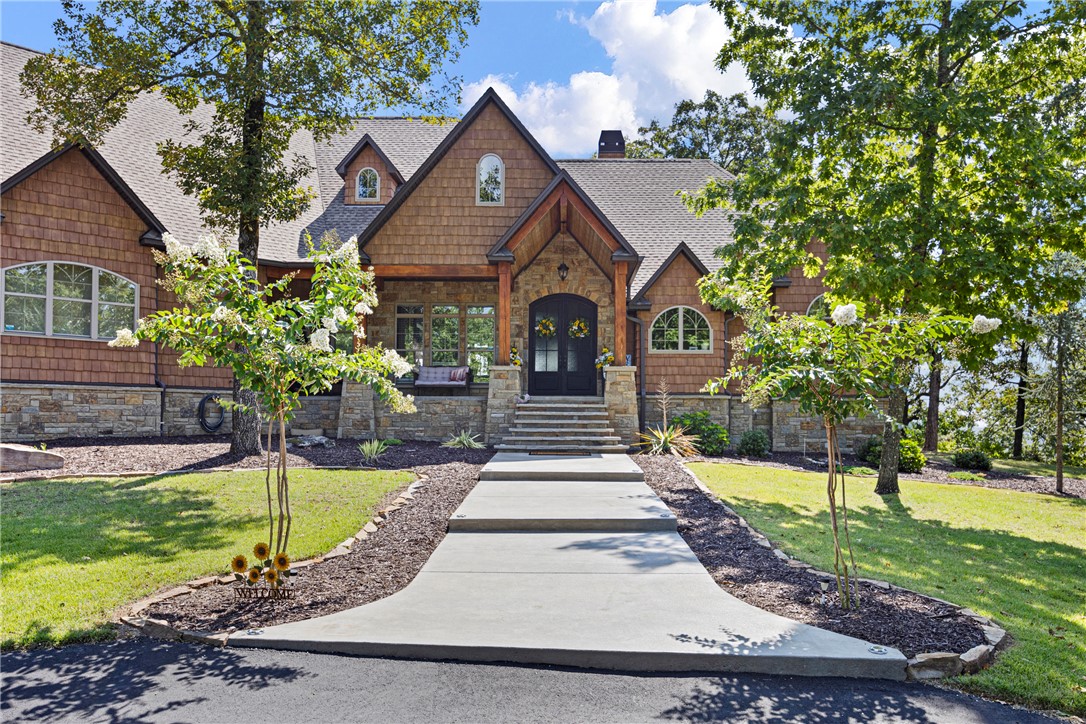Craftsman-style exterior featuring stone accents, shake siding, and a prominent front entry with double doors
