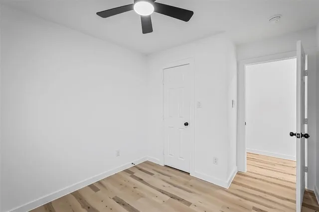 an empty room with a ceiling fan and a window