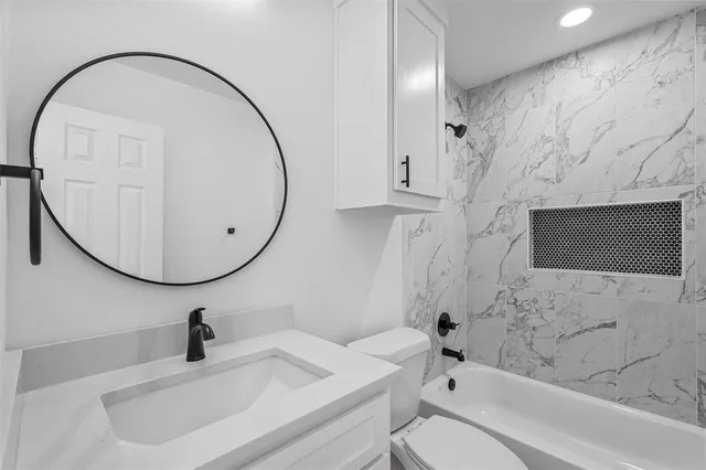 a bathroom with a sink a toilet and a mirror