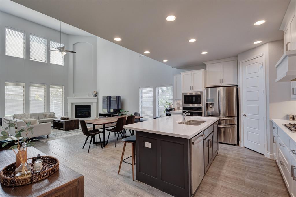 830 Knoxbridge Road Forney, TX 75126 - Photo 9 of 36 a living room with stainless steel appliances furniture a rug kitchen view and a large window