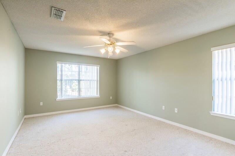 1607 Ella Ruth Drive Fort Walton Beach, FL 32547 - Photo 14 of 31 an empty room with windows and chandelier fan