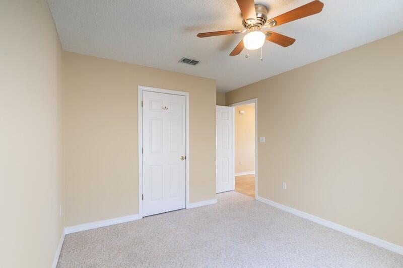 1607 Ella Ruth Drive Fort Walton Beach, FL 32547 - Photo 21 of 31 an empty room with a chandelier fan and a ceiling fan
