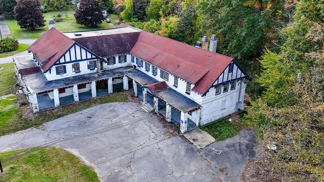 a aerial view of a house with a yard and large tree