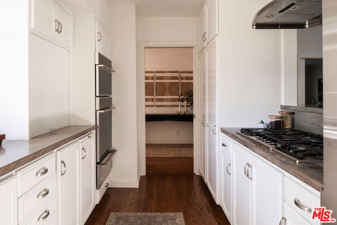 10225 Valley Spring Lane Toluca Lake, CA 91602 - Photo 12 of 35 a kitchen with white cabinets and appliances