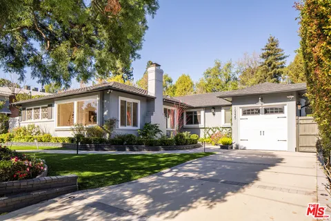 a living room with furniture a fireplace and a potted plant