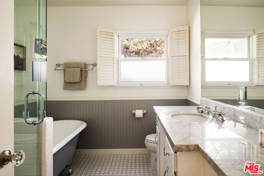 10225 Valley Spring Lane Toluca Lake, CA 91602 - Photo 22 of 35 a bathroom with a sink a toilet and window