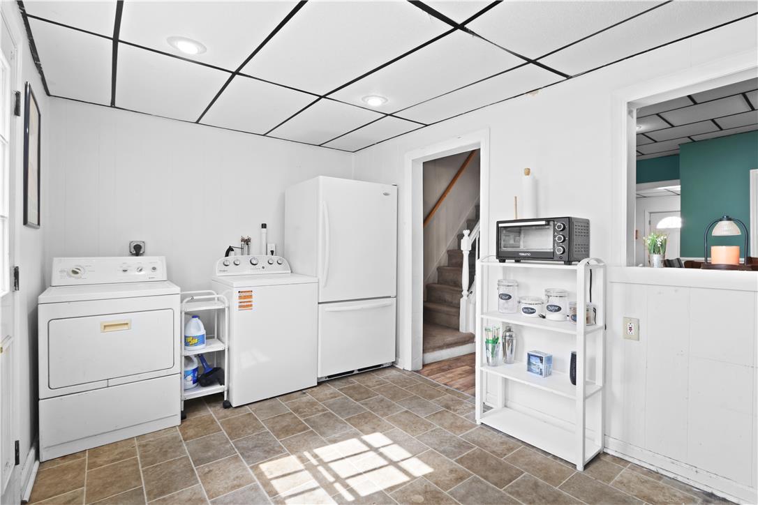 431 Pierce Street Bethlehem, PA 18015 - Photo 10 of 27 A utilitarian laundry zone, thoughtfully arranged with appliances and tiled flooring, transitions to a staircase.