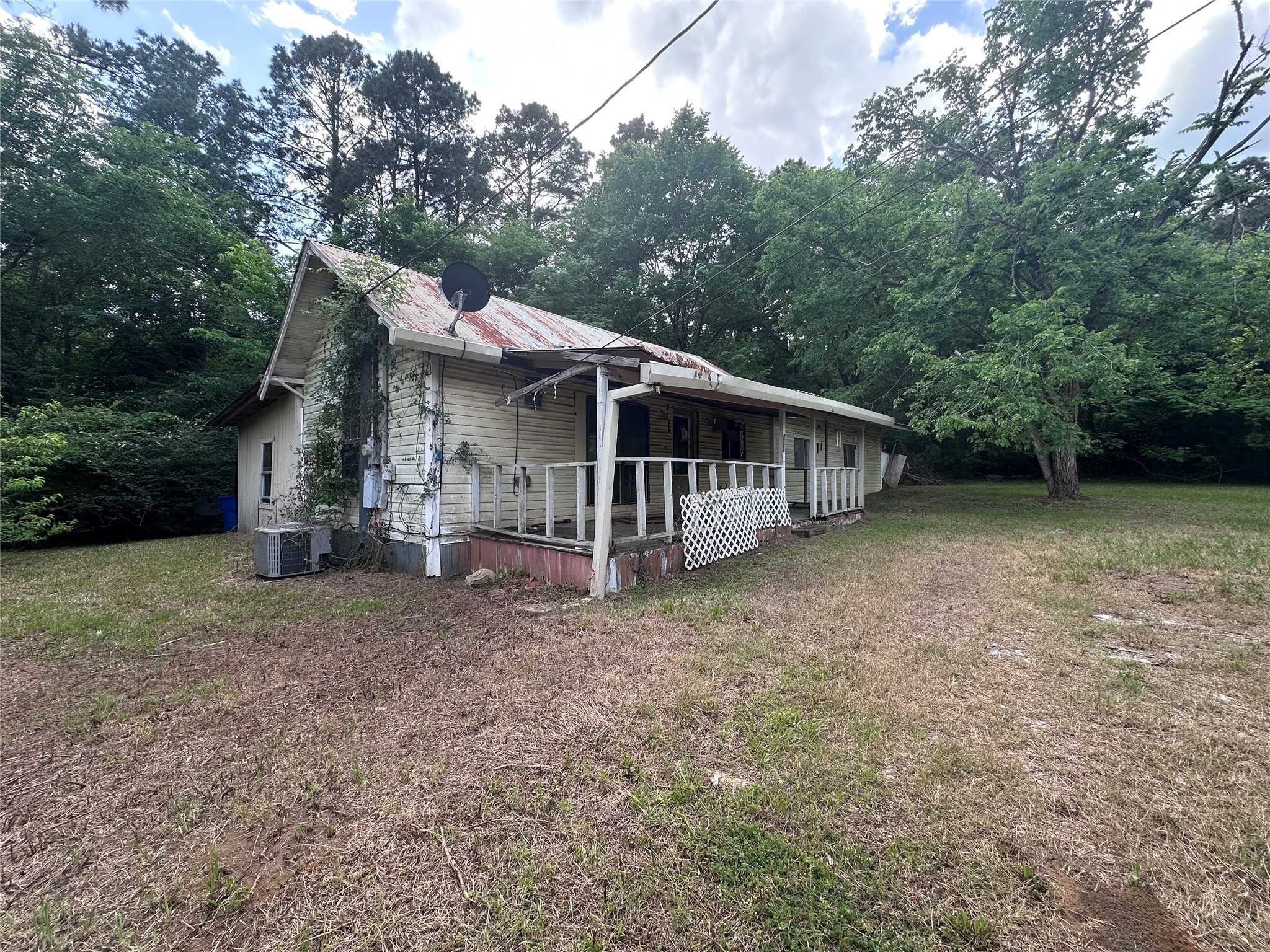 a view of a house with a yard and large trees