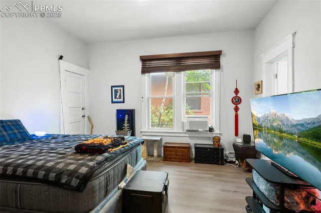 a bedroom with a bed and a large window