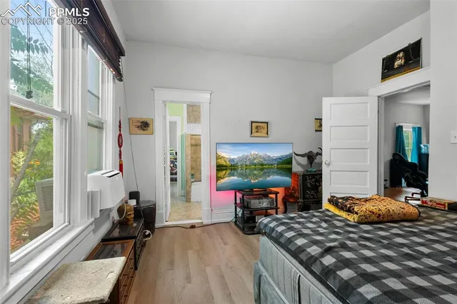 a bedroom with furniture and a large window