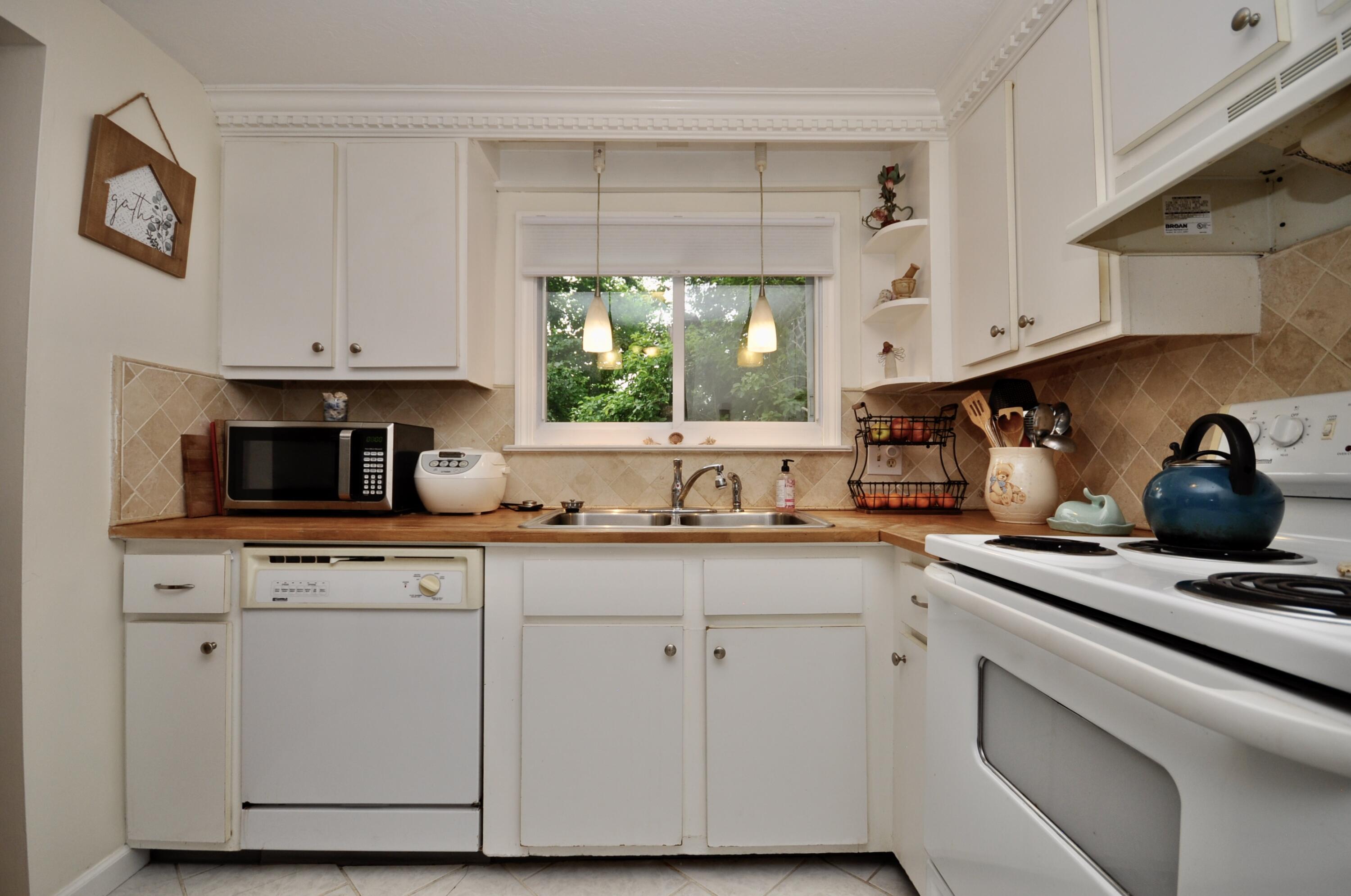 401 Village Drive Bourne, MA 02532 - Photo 6 of 22 a kitchen with cabinets appliances a sink and a window